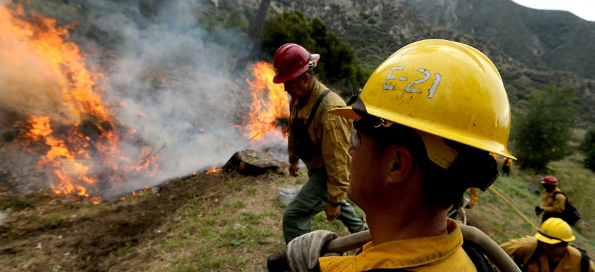 U.S. Forest Service firefighters in the Angeles National Forest burn piles of forest debris below Mt. Baldy on Nov. 29, 2023. Controlled burns are part of the service's forest management practices. 